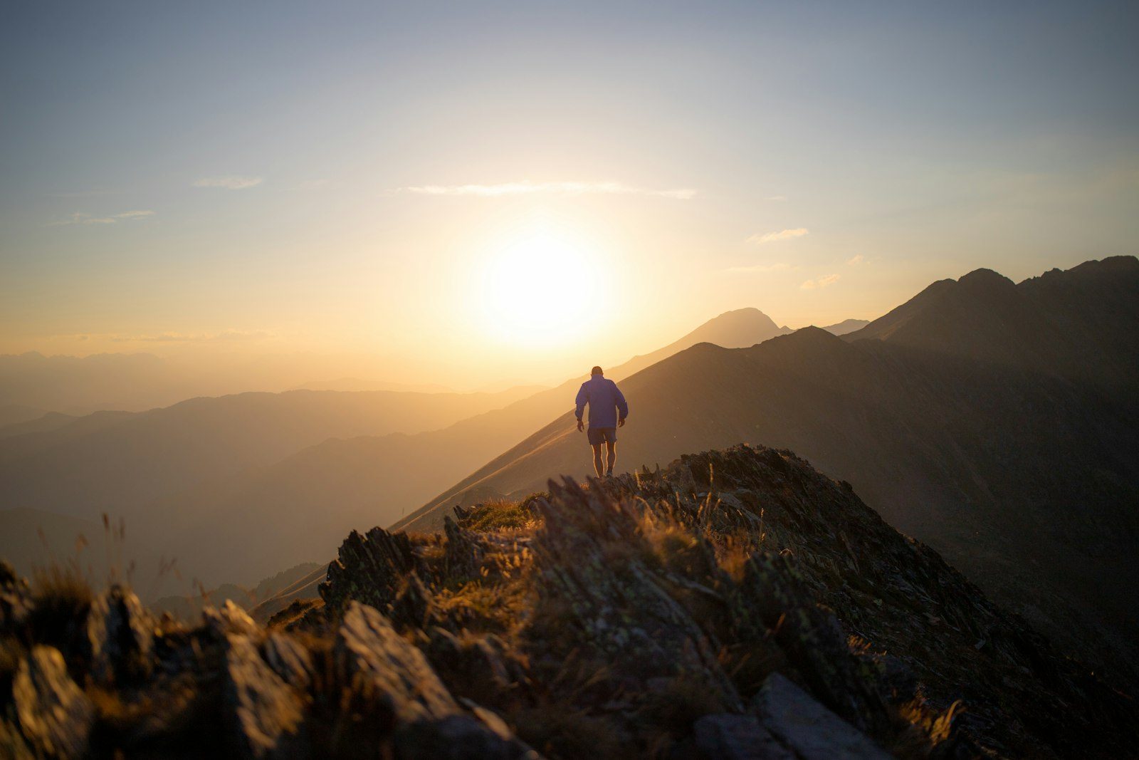 Solo hiker on a mountain summit at golden hour